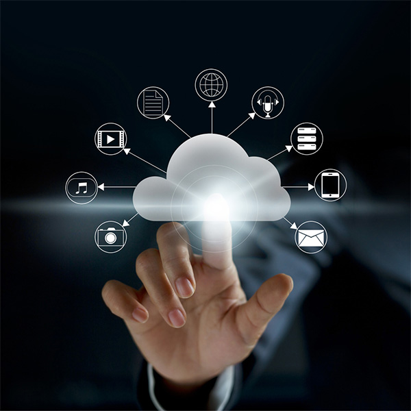 Image of a man's hand extended out with his index finger taping an overlaying graphic of a cloud. There are various icons tied to tech such as phones, email, music, and cameras. This image is to represent Manage IT Services.
