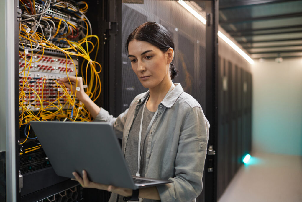This female network technician working in a data center is an example of a IT specialist