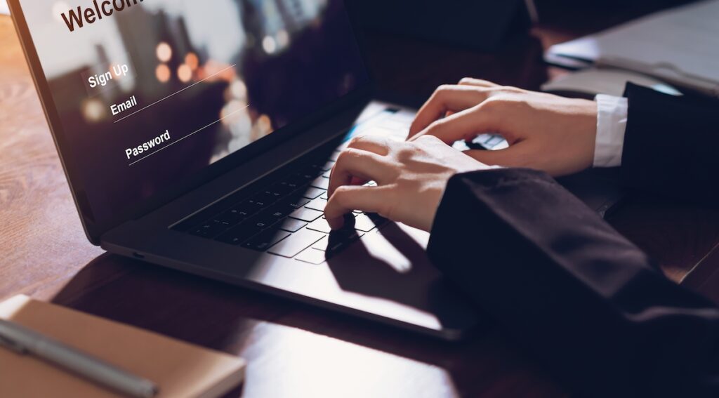 Business woman hands typing on laptop computer with sign up and password to online website. How to Encrypt Email in Outlook